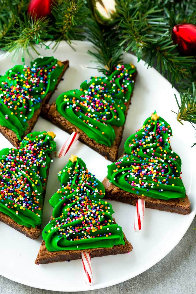 title="Christmas Tree Brownies | Christmas Brownies | Holiday Brownies | Christmas Tree Dessert #brownies #dessert #christmas #holiday #dessert #sadud" Christmas Brownies topped with frosting and rainbow sprinkles on a plate.