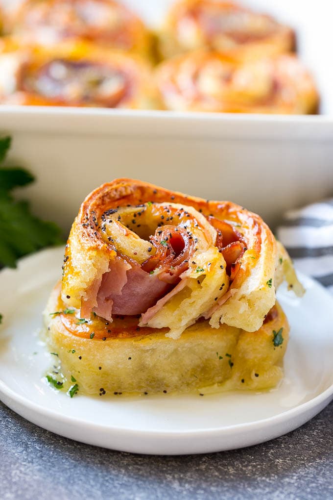 Ham and Cheese Pinwheels Recipe | Ham and Cheese Roll Ups | Ham and Cheese Rolls | Ham and Cheese Bread Rolls #ham #cheese #appetizer #pinwheels #sadud Ham and cheese pinwheels stacked on a serving plate.