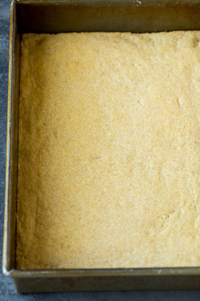 Pecan Pie Bars Recipe #pecans #pie #fall #pecanpie #dessert #thanksgiving #sadud A shortbread crust in a baking pan.