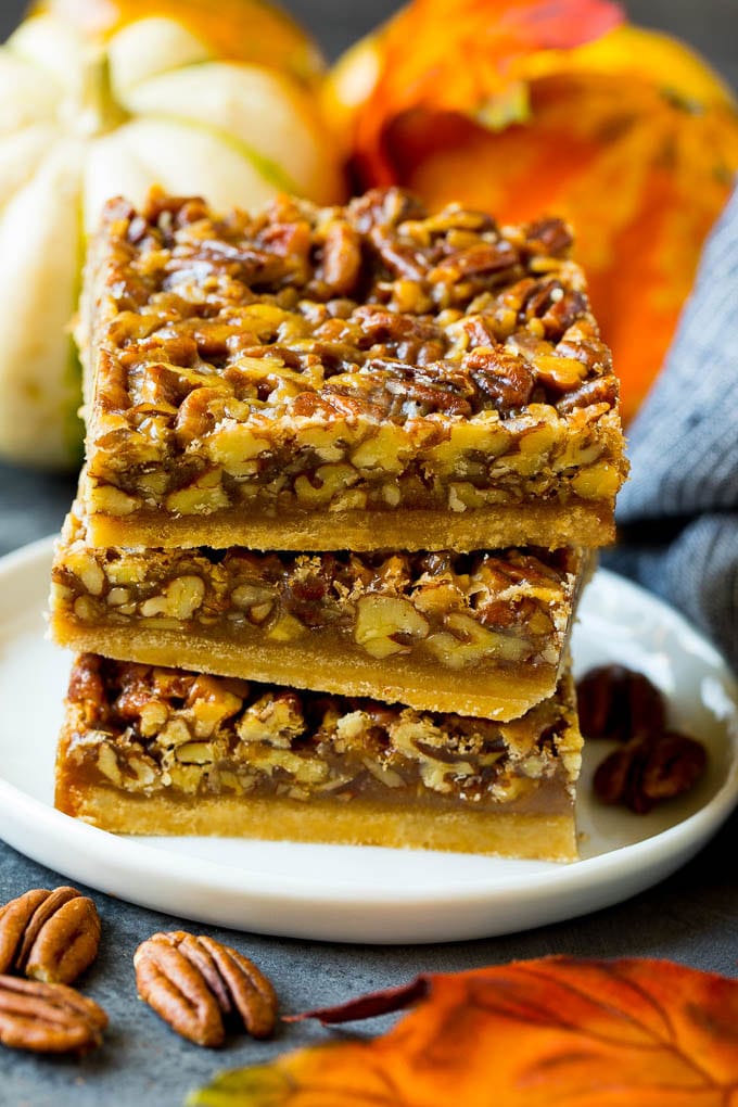 Pecan Pie Bars Recipe #pecans #pie #fall #pecanpie #dessert #thanksgiving #sadud A stack of pecan pie bars on a plate.