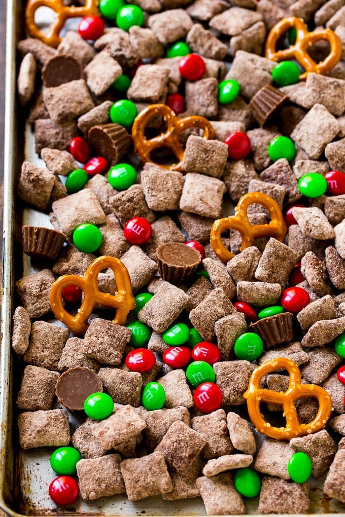 Reindeer Chow | Christmas Chex Mix | Christmas Muddy Buddies | Holiday Chex Mix #chex #chexmix #christmas #holiday #muddybuddies #reindeerchow #snack #sadud A sheet pan of Christmas muddy buddies mixed with candy and peanut butter cups.