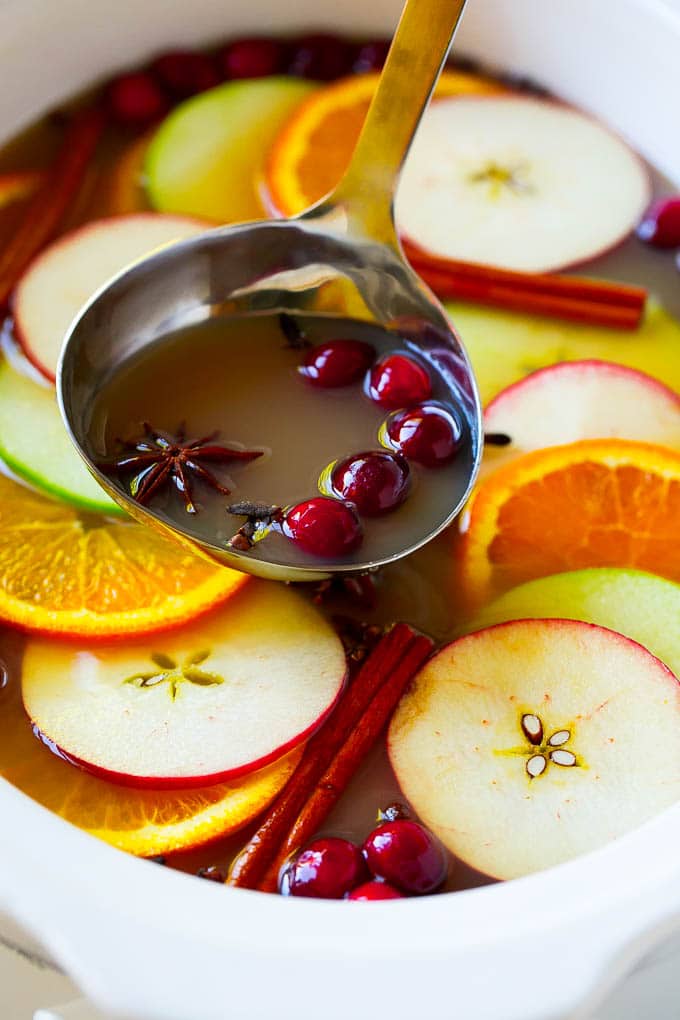 Slow Cooker Apple Cider | Mulled Apple Cider | Crockpot Apple Cider #cider #apple #applecider #drink #crockpot #slowcooker #sadud A ladle scooping out some warm mulled drink.