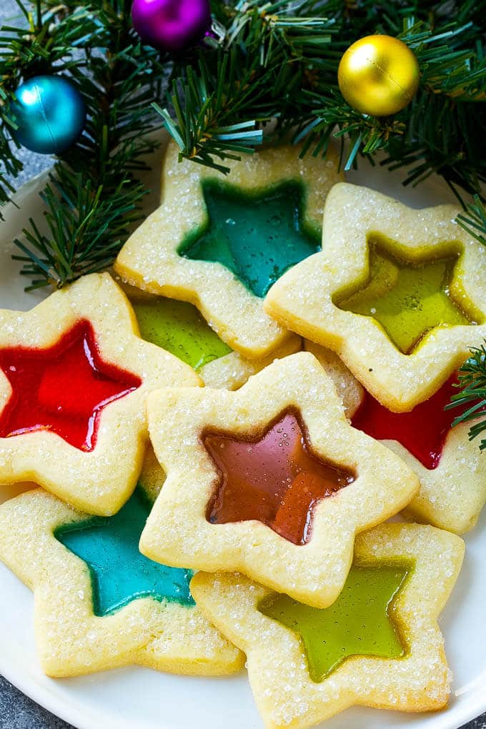Stained Glass Cookies | Stained Glass Window Cookies | Christmas Cookies | Sugar Cookies | Holiday Cookies #cookies #stainedglasscookies #sugarcookies #christmascookies #christmas #holiday #dessert #sadud A plate of star shaped stained glass cookies with colorful centers.