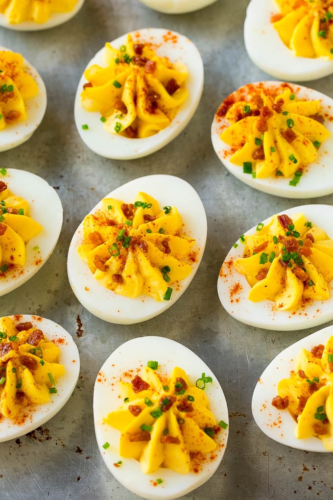 Bacon Deviled Eggs | Deviled Eggs Recipe #eggs #keto #lowcarb #bacon #appetizer #sadud Bacon deviled eggs topped with chives and paprika on a sheet pan.
