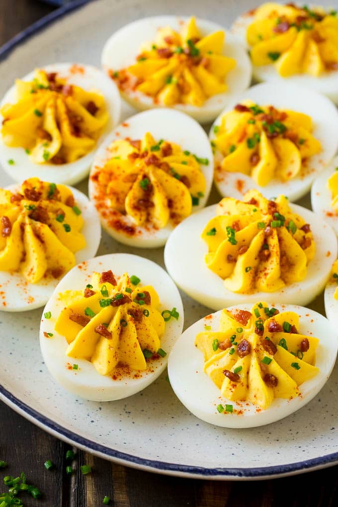 Bacon Deviled Eggs | Deviled Eggs Recipe #eggs #keto #lowcarb #bacon #appetizer #sadud A plate of bacon deviled eggs garnished with sliced chives and smoked paprika.