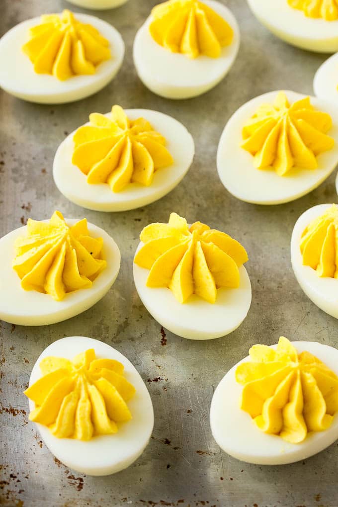 Bacon Deviled Eggs | Deviled Eggs Recipe #eggs #keto #lowcarb #bacon #appetizer #sadud Deviled eggs with a decoratively piped filling on a sheet pan.