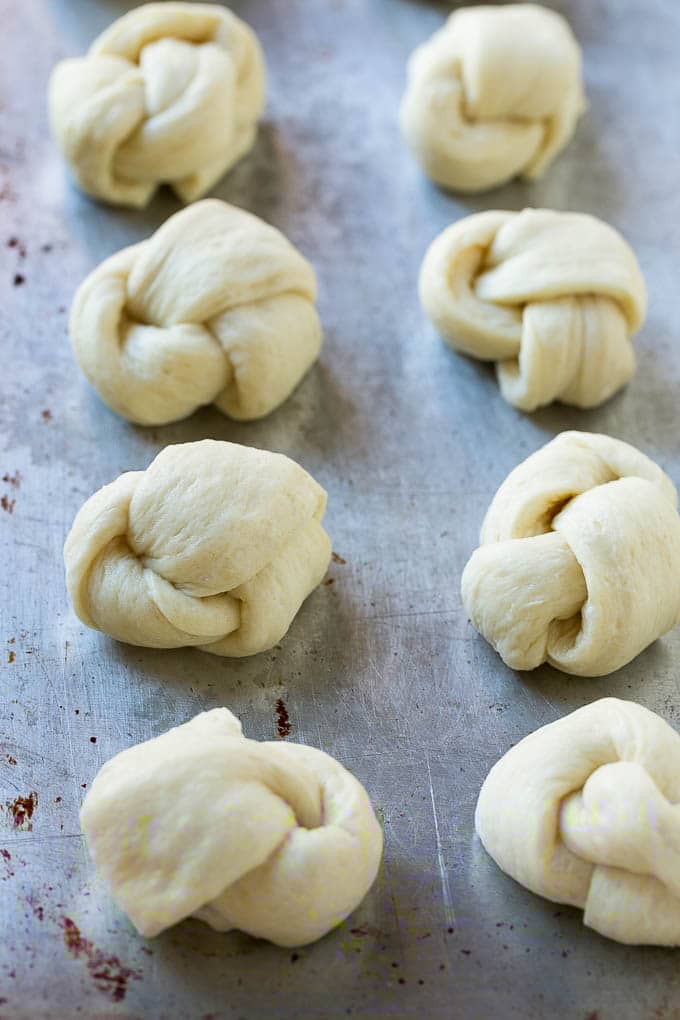 Garlic Knots Recipe | Garlic Rolls | Garlic Butter Rolls | Garlic Bread Recipe #garlic #garlicbread #garlicknots #breadsticks #sadud Pizza dough tied up and placed on a sheet pan.
