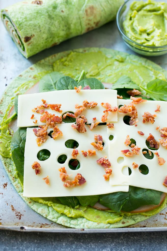 Turkey Roll Ups Recipe | Turkey Pinwheel Sandwiches | Turkey Roller Sandwiches #turkey #avocado #sandwich #lunch #appetizer #sadud A spinach tortilla layered with turkey, spinach, cheese and bacon.
