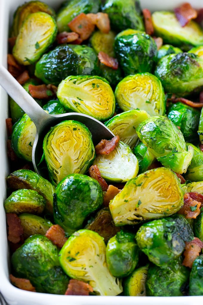 These bacon roasted brussels sprouts are crispy on the outside, soft on the inside and full of smoky flavor. A serving dish full of roasted brussels sprouts with bacon and parsley.