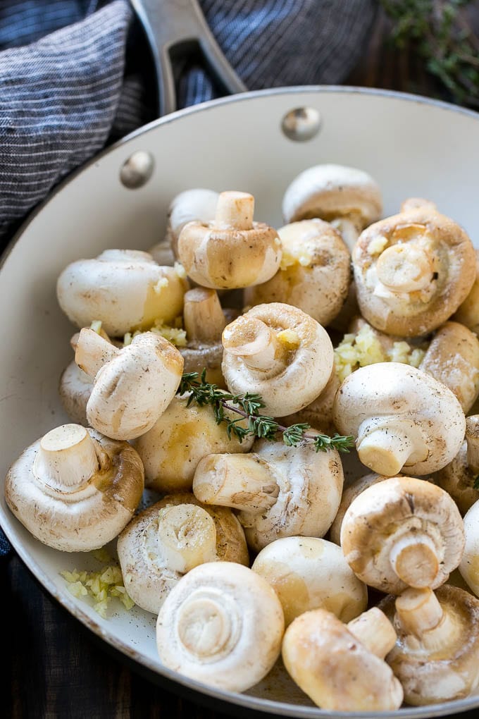 Garlic Mushrooms Recipe | Steakhouse Mushrooms | Sauteed Mushrooms | Garlic Butter Mushrooms | Mushroom Side Dish #mushrooms #butter #keto #lowcarb #dinner #sidedish #sadud Uncooked buttons with herbs and butter in a frying pan.