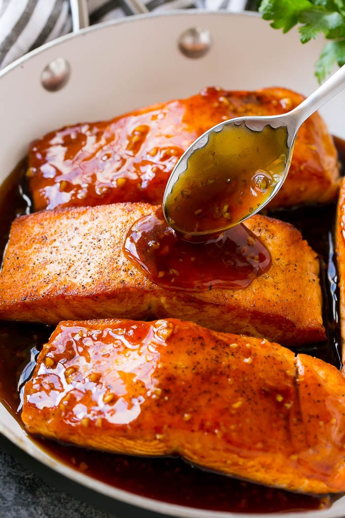Honey Garlic Salmon Recipe | Asian Salmon Recipe | Healthy Salmon Recipe #salmon #fish #seafood #healthy #dinner #sadud A spoon pouring sauce on top of salmon fillets.