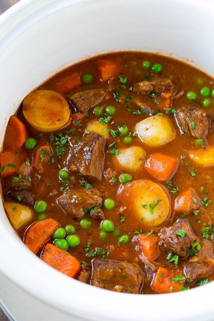 Slow Cooker Beef Stew Recipe | Beef and Potato Stew | Crock Pot Beef Stew | Easy Beef Stew #beef #beefstew #soup #slowcooker #crockpot #dinner #sadud A slow cooker full of beef stew that contains meat, potatoes, carrots and peas, all in a savory broth.