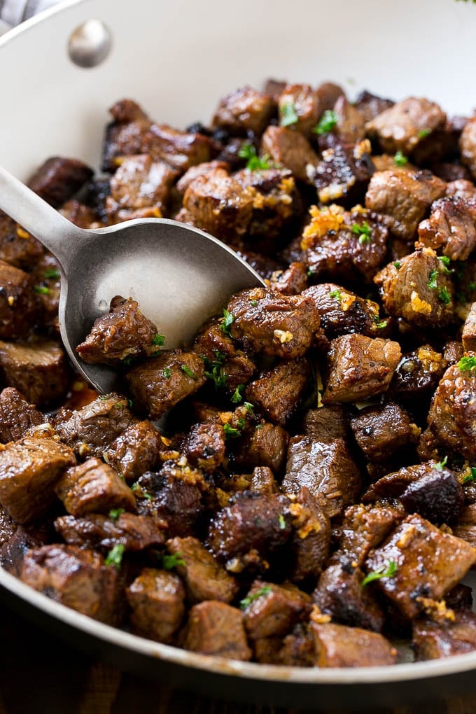 Steak Bites in Garlic Butter Recipe | Garlic Steak | Sirloin Steak Recipe | Steak Appetizer #steak #lowcarb #keto #sadud #dinner A pan of steak bites with a serving spoon.