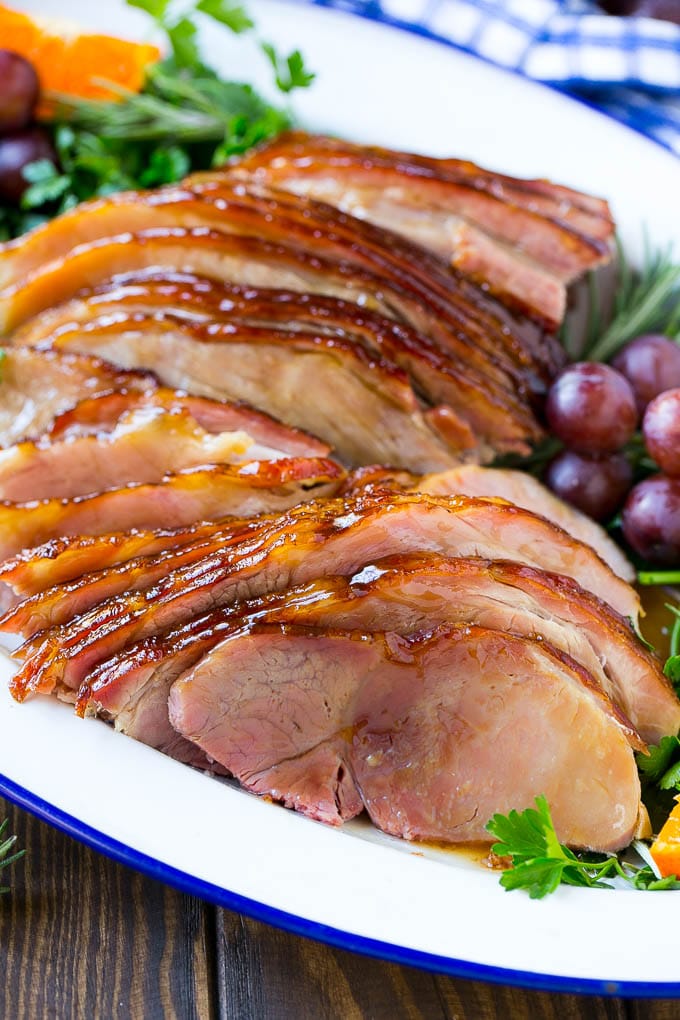Coca Cola Ham | Coke Glazed Ham | Easter Ham | Christmas Ham | Holiday Ham Recipe #ham #easter #christmas #dinner #sadud A platter of sliced coca cola ham with herbs.