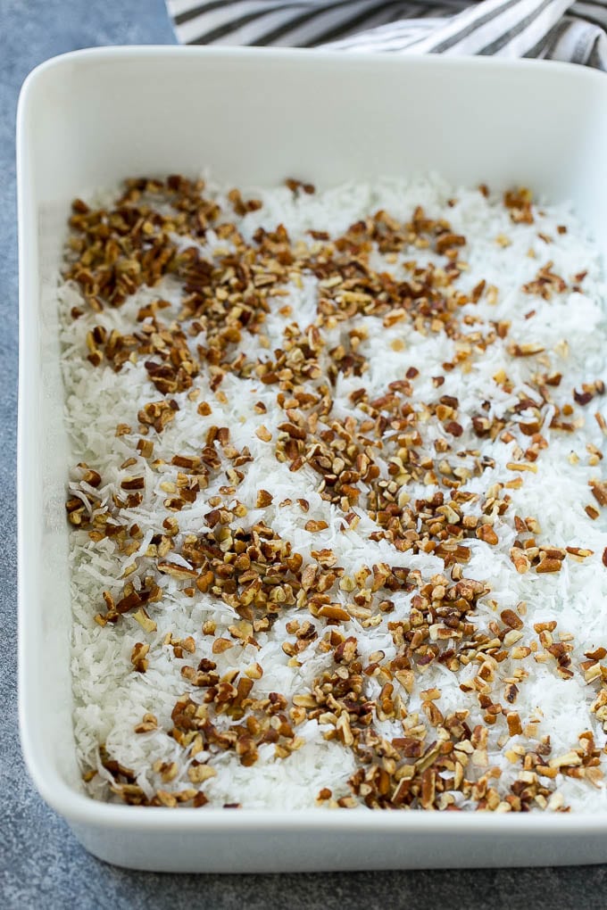 Earthquake Cake Recipe | Chocolate Cake Recipe | Chocolate Coconut Cake | Coconut Pecan Cake #cake #chocolate #coconut #pecans #dessert #chocolatecake #sadud Coconut and pecans layered into a cake pan.