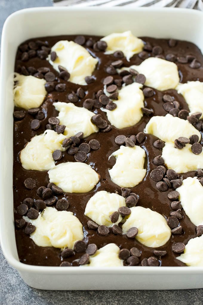 Earthquake Cake Recipe | Chocolate Cake Recipe | Chocolate Coconut Cake | Coconut Pecan Cake #cake #chocolate #coconut #pecans #dessert #chocolatecake #sadud Chocolate cake batter topped with dollops of sweetened cream cheese and chocolate chips.