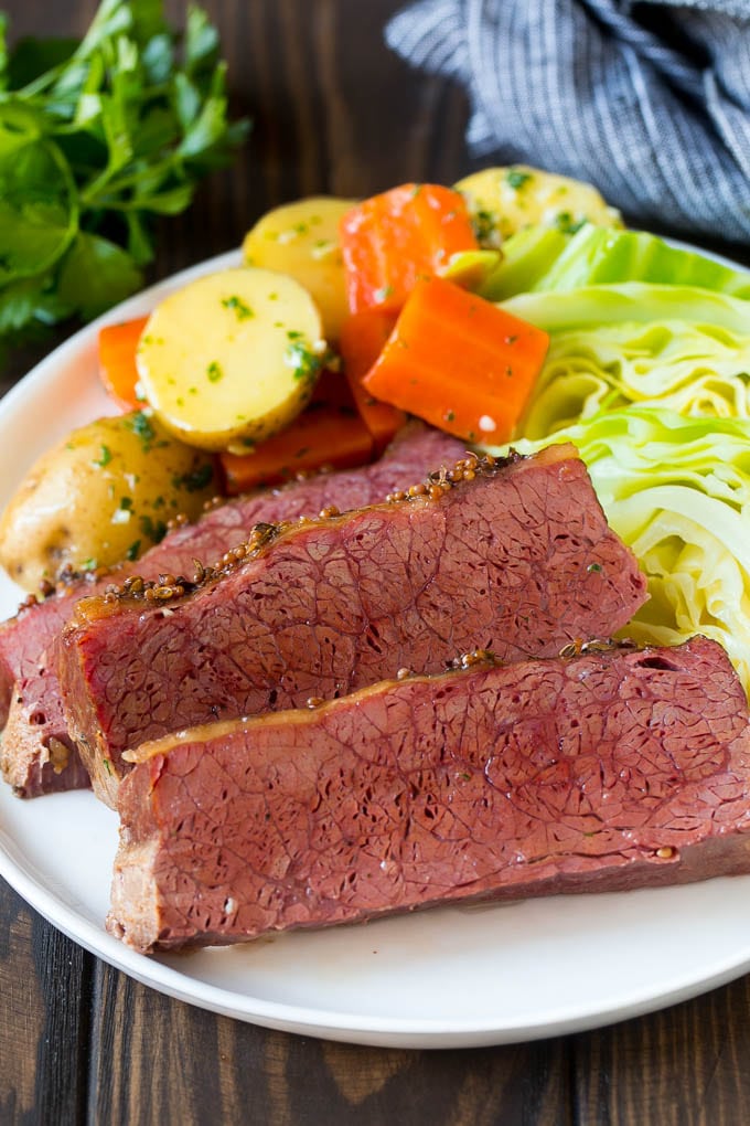 Slow Cooker Corned Beef Recipe | Crock Pot Corned Beef | Corned Beef and Cabbage #beef #cornedbeef #cabbage #potatoes #carrots #stpatricksday #irish #sadud Sliced slow cooker corned beef on a plate with carrots, potatoes and cabbage.