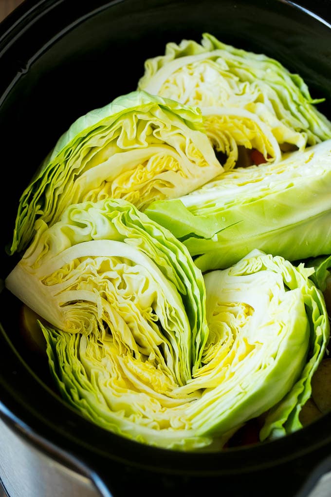 Slow Cooker Corned Beef Recipe | Crock Pot Corned Beef | Corned Beef and Cabbage #beef #cornedbeef #cabbage #potatoes #carrots #stpatricksday #irish #sadud Cabbage wedges inside a crock pot.