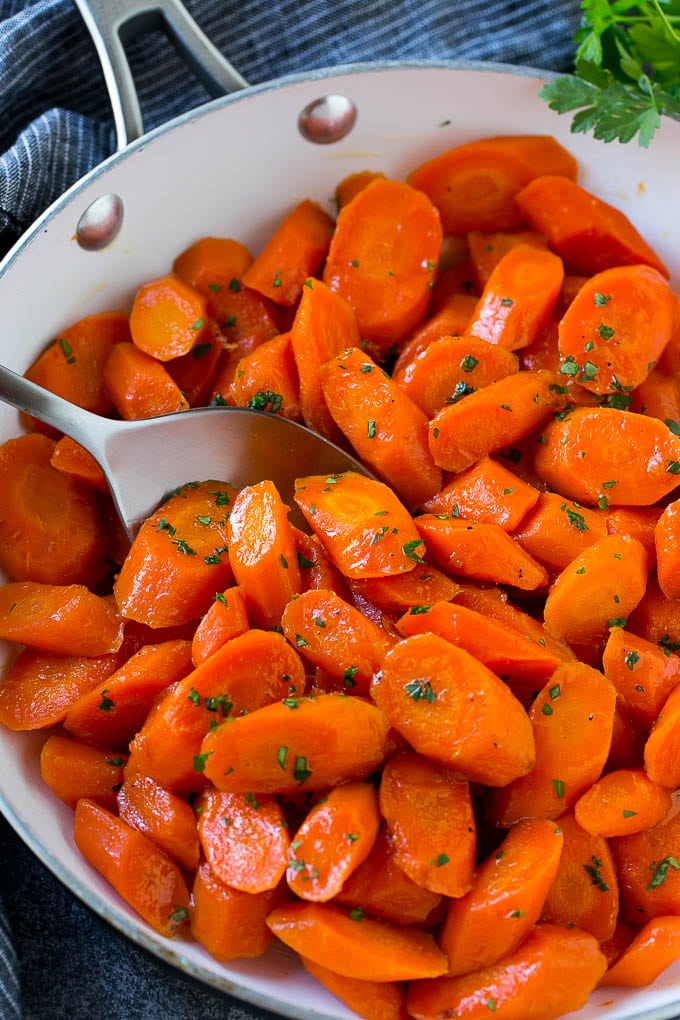 Candied Carrots Recipe | Carrot Side Dish | Brown Sugar Carrots | Glazed Carrots #carrots #brownsugar #sidedish #dinner #sadud Candied carrots in a pan with a serving spoon.