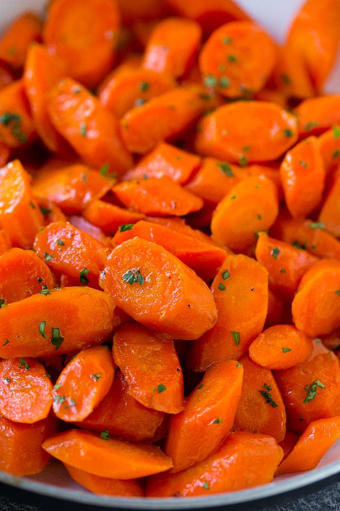 Candied Carrots Recipe | Carrot Side Dish | Brown Sugar Carrots | Glazed Carrots #carrots #brownsugar #sidedish #dinner #sadud A close up of cooked candied carrots topped with parsley.