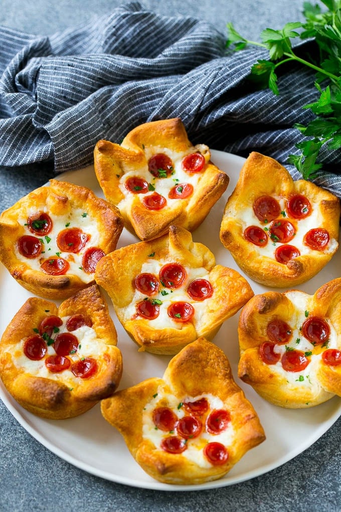 Pizza Muffins Recipe | Pizza Bites | Pizza Cups | Pizza Appetizer #pizza #appetizer #sadud Pizza muffins on a serving plate garnished with parsley.