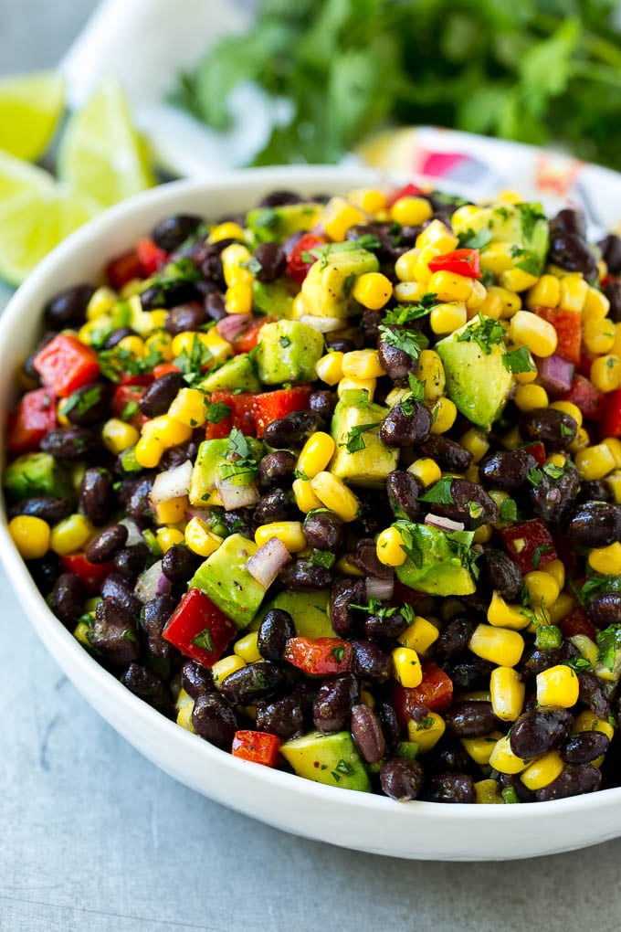 Black Bean and Corn Salad Recipe | Mexican Salad | Black Bean Salad | Bean Salad #salad #beans #corn #mexicanfood #sadud A bowl of black bean and corn salad loaded with avocado and red pepper, garnished with fresh cilantro.
