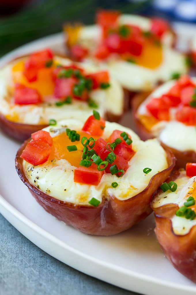 Ham and Egg Cups Recipe | Low Carb Breakfast | Ham and Eggs #ham #eggs #lowcarb #breakfast #sadud A plate of ham and egg cups topped with diced tomatoes and chives.