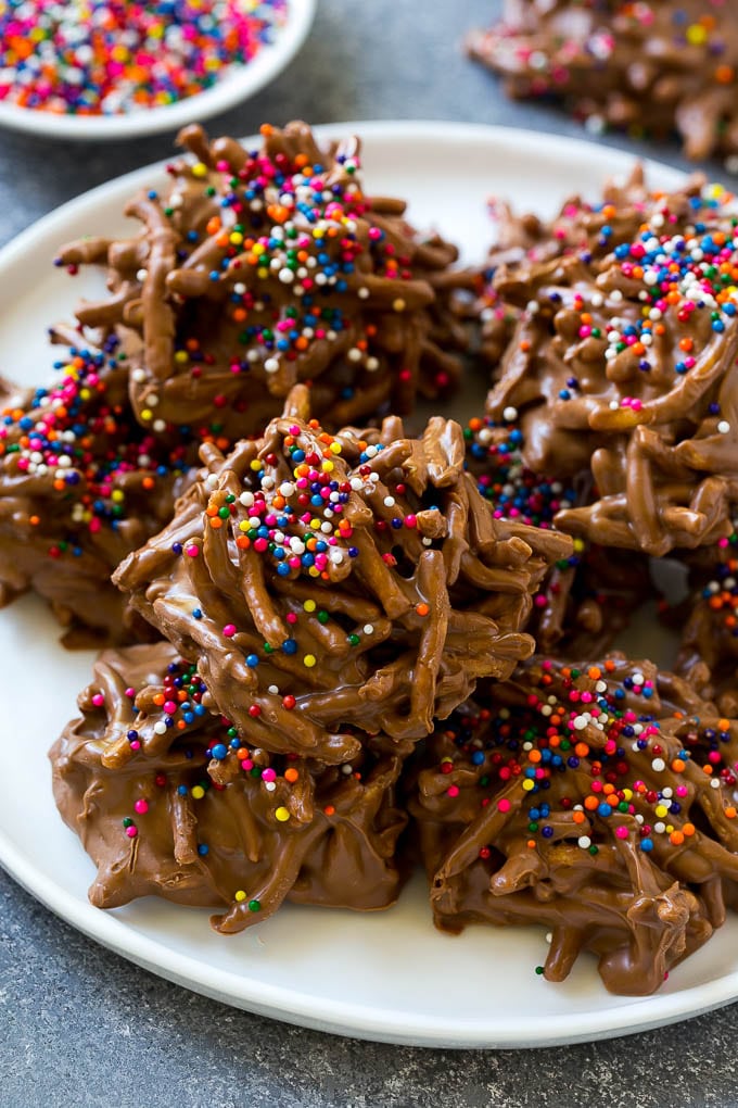 Haystack Cookies Recipe | No Bake Cookies | Chow Mein Noodle Cookies #nobakecookies #cookies #recipe #chocolate #sadud A plate of haystack cookies topped with rainbow sprinkles.