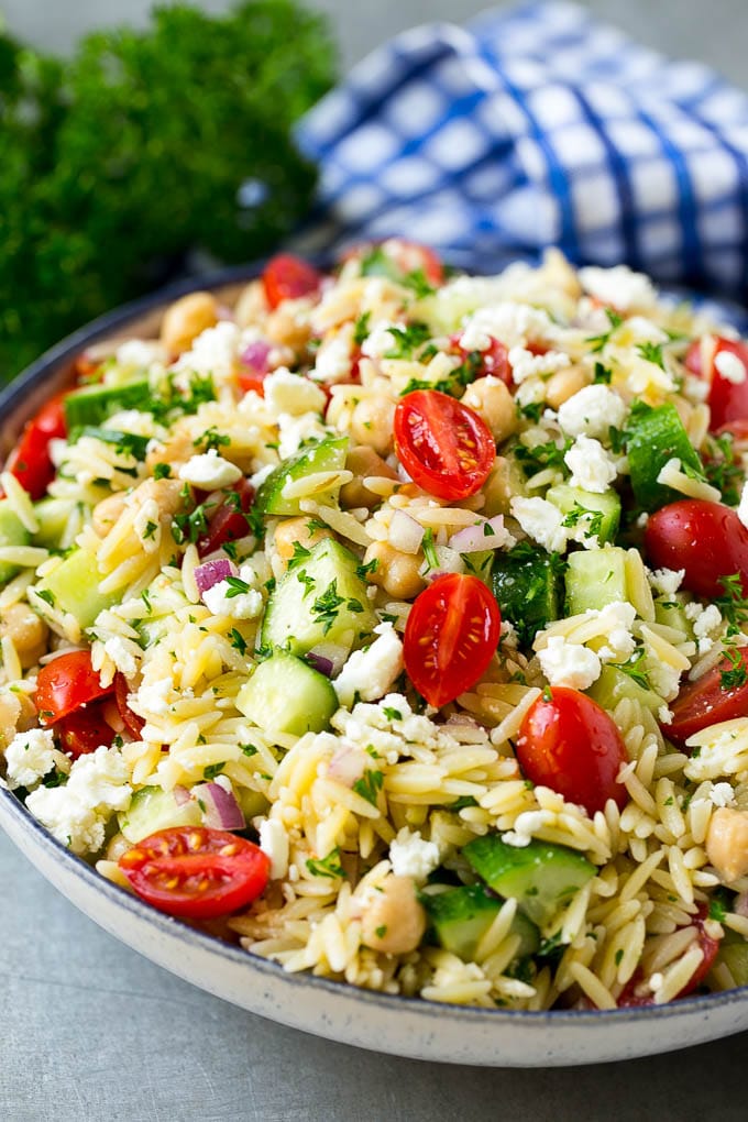 Orzo Salad Recipe | Orzo Pasta Salad | Greek Orzo Salad | Mediterranean Orzo Salad #pastasalad #orzo #greekfood #salad #sadud Orzo salad in a serving bowl with tomatoes, cucumbers and chickpeas.