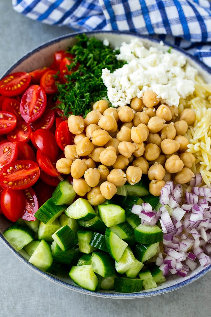 Orzo Salad Recipe | Orzo Pasta Salad | Greek Orzo Salad | Mediterranean Orzo Salad #pastasalad #orzo #greekfood #salad #sadud A bowl of orzo pasta, cucumbers, cherry tomatoes, feta cheese, red onions, herbs and chickpeas.