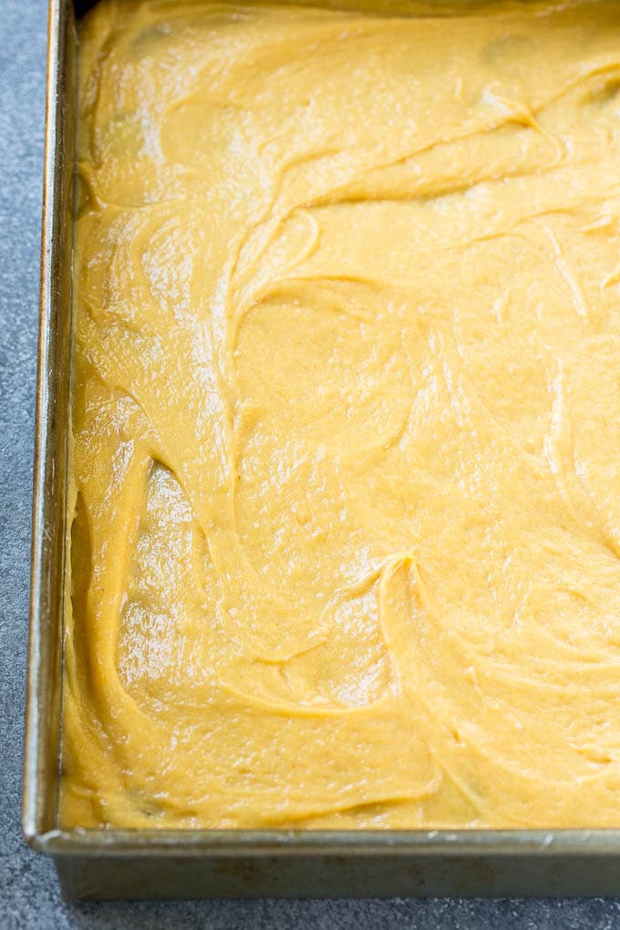 A layer of peanut butter filling on top of chocolate cake crust in a baking pan.