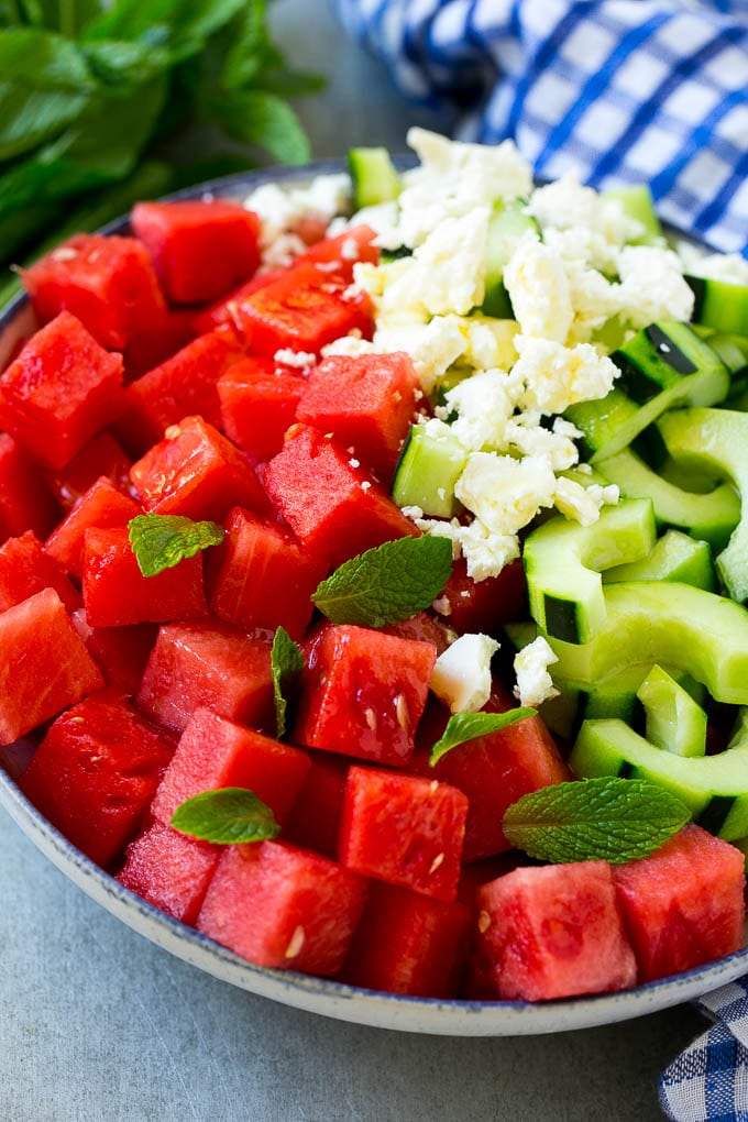 Watermelon Salad Recipe | Watermelon Feta Salad | Watermelon Cucumber Salad #watermelon #cucumber #salad #sadud A bowl of watermelon, cucumber, feta cheese and mint leaves drizzled with lime dressing.