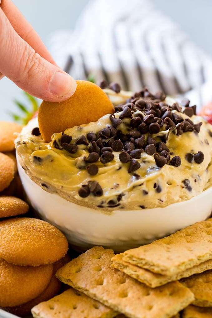 Cookie Dough Dip Recipe | Edible Cookie Dough | Chocolate Chip Cookie Dip #cookies #dip #cookiedough #dessert #snack #sadud A cookie scooping into a bowl of dip.