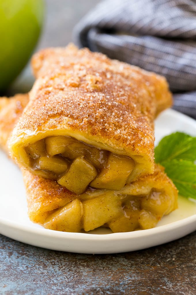 Fried Apple Pies Recipe | McDonald's Copycat Recipe | Apple Pie | Apple Hand Pies #pie #apples #applepie #dessert #snack #sadud A cross section of a fried apple pie on a plate.