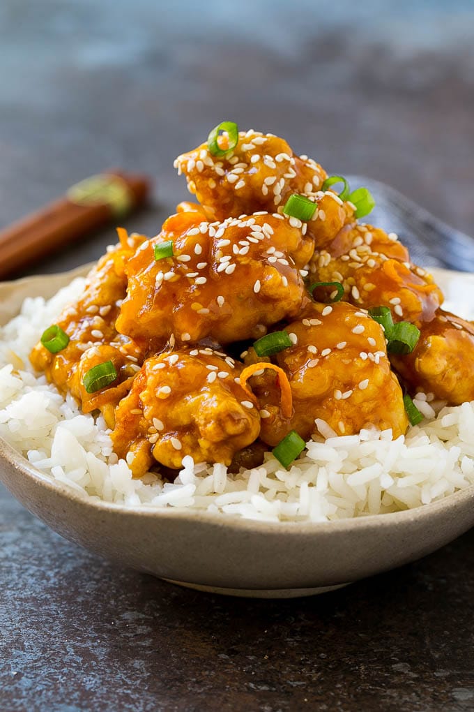 Orange Chicken Recipe | Chinese Orange Chicken | Panda Express Orange Chicken #orange #chicken #takeout #chinesefood #dinner #sadud A bowl of orange chicken served over steamed rice and topped with sesame seeds.