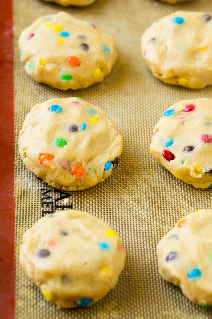 Oreo Stuffed Cookies Recipe | M&M's cookies | Stuffed Cookies #cookies #chocolate #oreos #dessert #baking #sadud Cookie dough balls stuffed with Oreo cookies on a sheet pan.