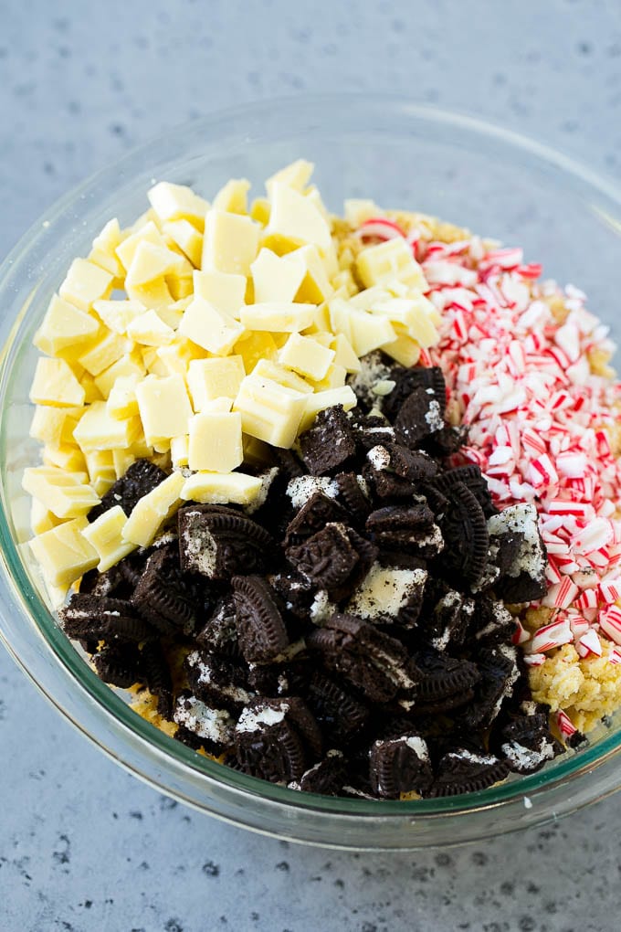 Oreo Peppermint Cookies Recipe | Candy Cane Cookies | Oreo Cookies #oreo #peppermint #cookies #baking #Christmas #sweets #sadud A bowl of dough with Oreo pieces, white chocolate chunks and crushed candy canes.