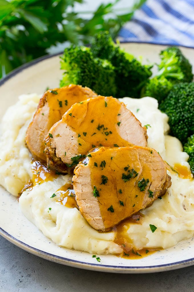 Slow Cooker Pork Tenderloin Recipe | Crock Pot Pork Tenderloin | Easy Pork Tenderloin #slowcooker #crockpot #pork #dinner #sadud Sliced slow cooker pork tenderloin served over mashed potatoes with broccoli.