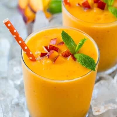 A peach smoothie in ice garnished with mint.