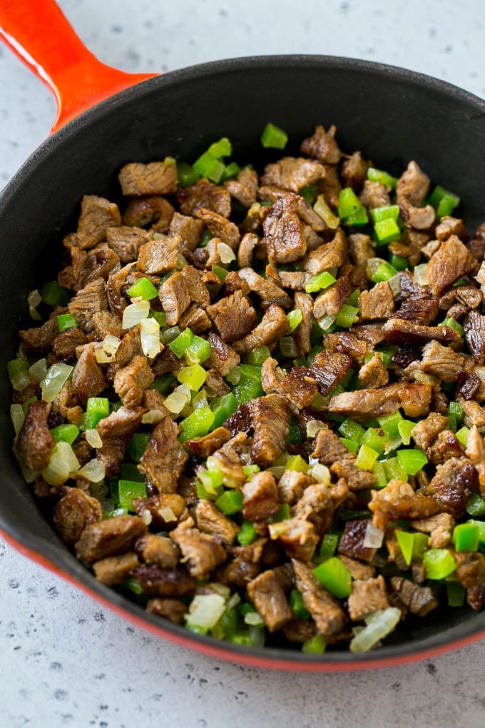 Philly Cheesesteak Dip Recipe | Cheesy Dip | Baked Cheese Dip #steak #dip #appetizer #cheese #sadud Seared rib eye steak, peppers and onions in a pan.