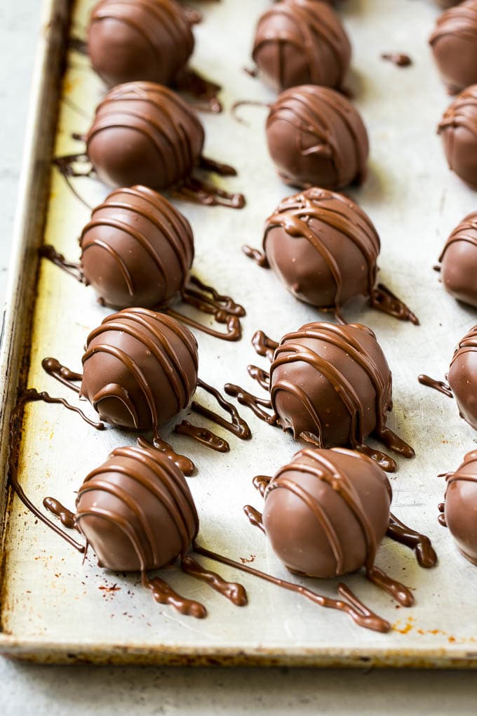 Chocolate Covered Cherries Recipe | Cherry Cordials | Cherry Candy #chocolate #candy #dessert #cherry #sweets #sadud Chocolate covered cherries on a sheet pan with a chocolate drizzle on top.