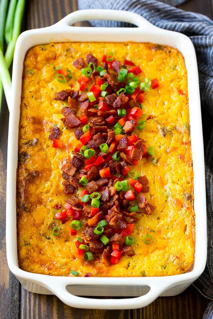 Loaded Corn Casserole Recipe | Easy Corn Casserole | Bacon Corn Casserole | Corn Pudding #corn #casserole #bacon #cheese #sidedish #thanksgiving #dinner #sadud A casserole of loaded corn casserole topped with bacon, red peppers and green onions.