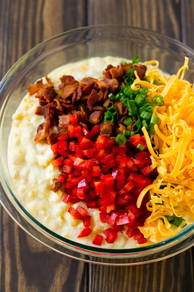 Loaded Corn Casserole Recipe | Easy Corn Casserole | Bacon Corn Casserole | Corn Pudding #corn #casserole #bacon #cheese #sidedish #thanksgiving #dinner #sadud A bowl of batter with red pepper, green onions, cheddar cheese and bacon.