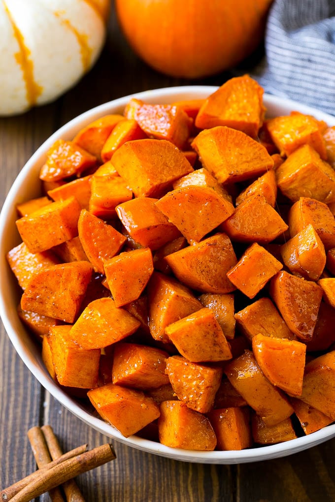 Maple Roasted Sweet Potatoes Recipe | Easy Sweet Potatoes | Baked Sweet Potatoes | Sweet Potato Side Dish #sweetpotatoes #cinnamon #maple #butter #fall #sidedish #dinner #sadud A bowl of maple roasted sweet potatoes with cinnamon and butter on top.