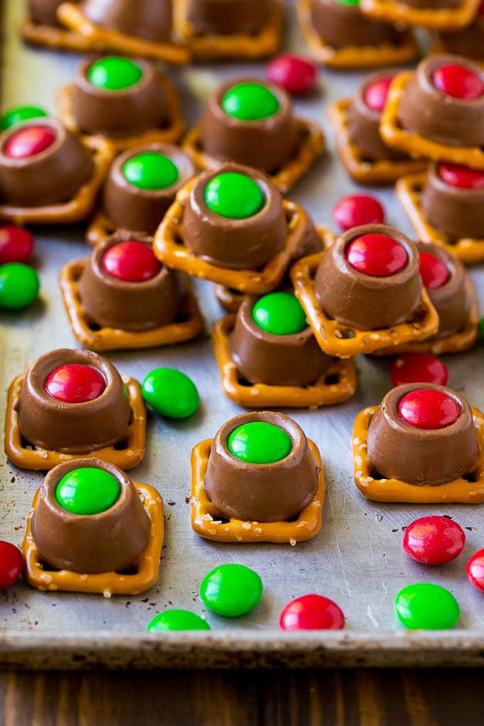Rolo Pretzels Recipe | Chocolate Pretzels | Caramel Pretzels | Holiday Candy #christmas #baking #dessert #candy #chocolate #caramel #pretzels #sadud Rolo pretzels on a baking sheet topped with red and green M&M's.