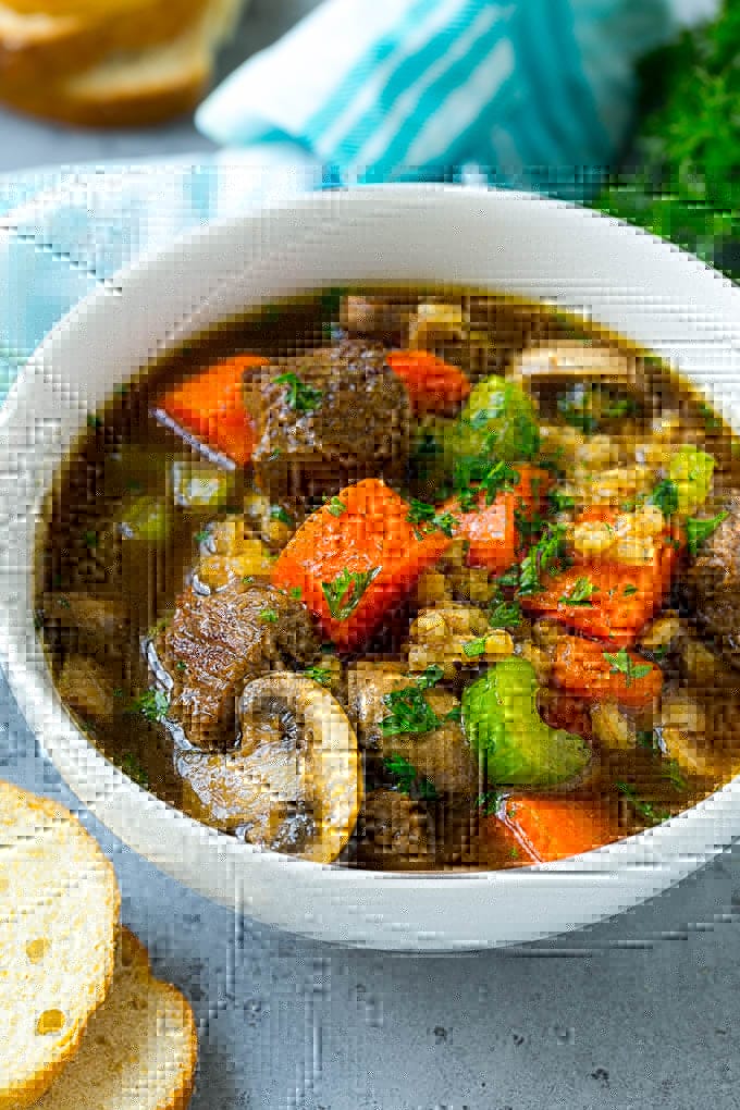 Beef Barley Soup Recipe | Beef Soup | Barley Soup #soup #beef #dinner #vegetables #sadud #comfortfood A bowl of beef barley soup topped with chopped parsley.