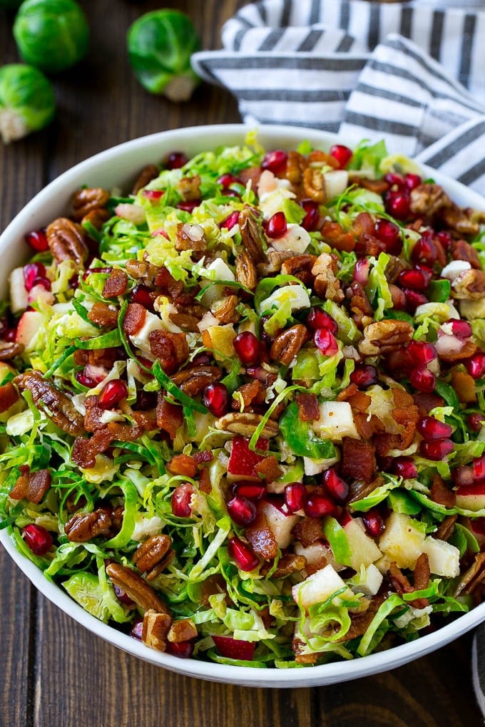 Brussels Sprout Salad Recipe | Shredded Brussels Sprouts Salad | Fall Salad #salad #brusselssprouts #bacon #thanksgiving #pomegranate #apple #dinner #sadud A bowl of salad made with pomegranate, bacon and apples.