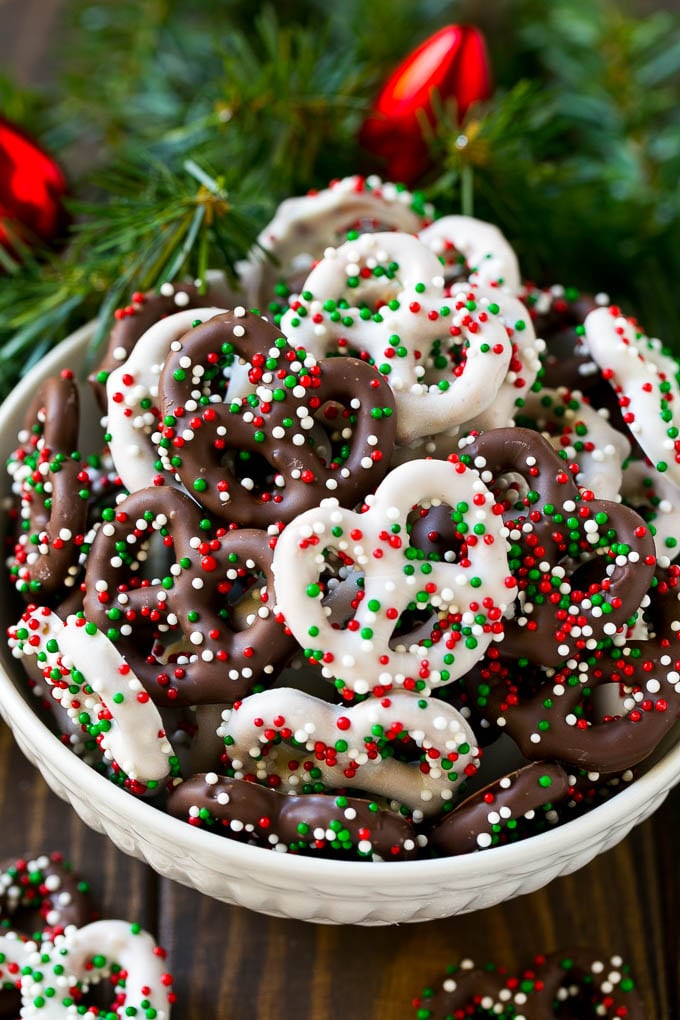 Chocolate Covered Pretzels Recipe | Sprinkle Pretzels | No Bake Dessert #pretzels #chocolate #christmas #sprinkles #candy #sadud Chocolate covered pretzels in a bowl with Christmas sprinkles.