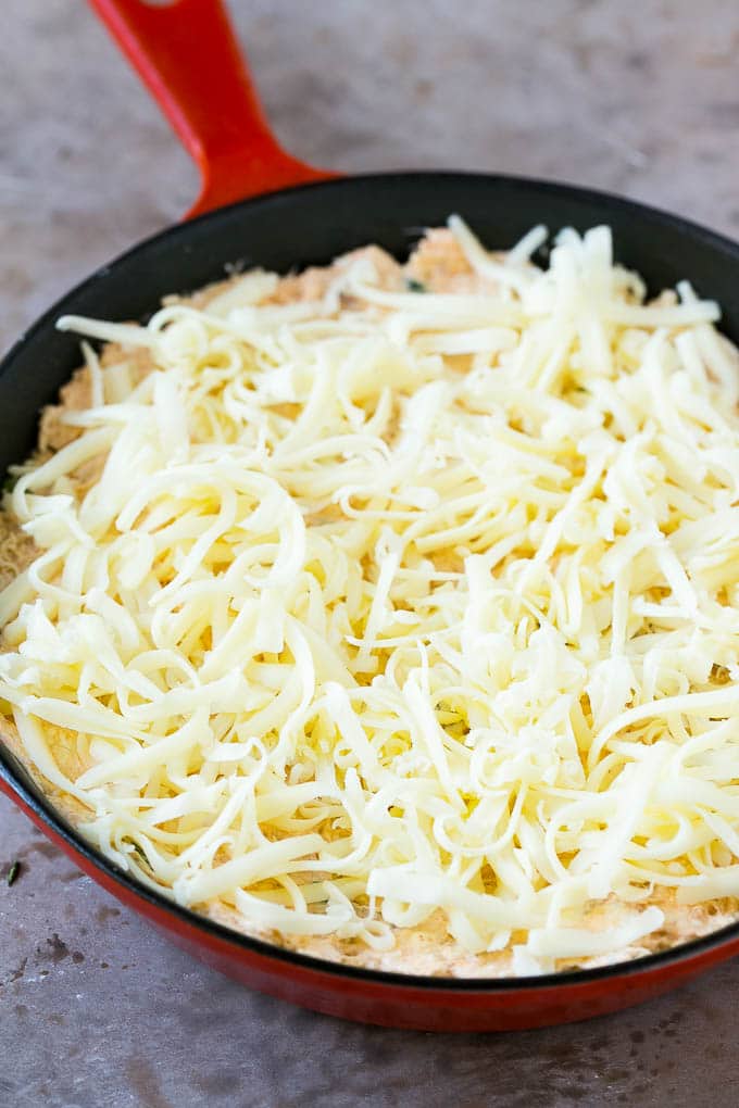 Crab Dip Recipe | Hot Crab Dip | Seafood Dip #dip #crab #seafood #appetizer #sadud #cheese Shredded Monterey Jack cheese sprinkled over a skillet of mixture.
