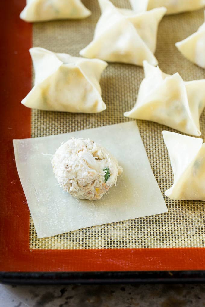 Crab Rangoon Recipe | Crab Wontons | Cream Cheese Wontons #crab #cheese #appetizer #snack #chinesefood #dinner #sadud A wonton wrapper with a dollop of filling on it.